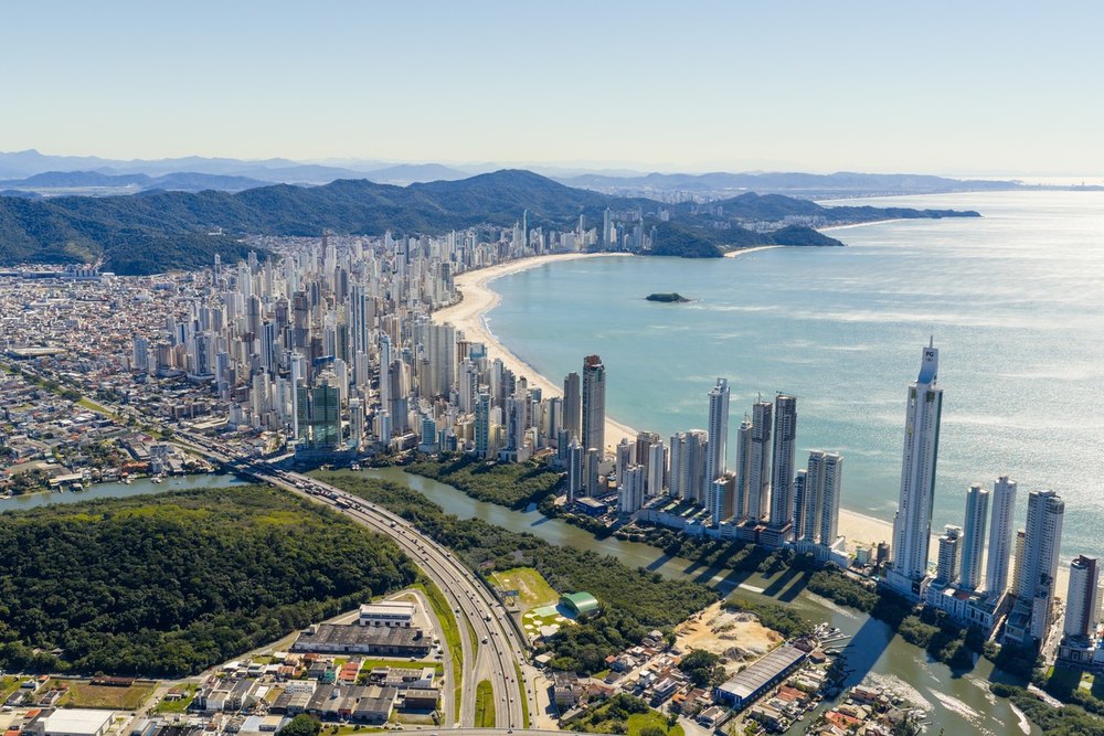 Vista aérea de Balneário Camboriú, com a orla de prédios, a praia e o mar