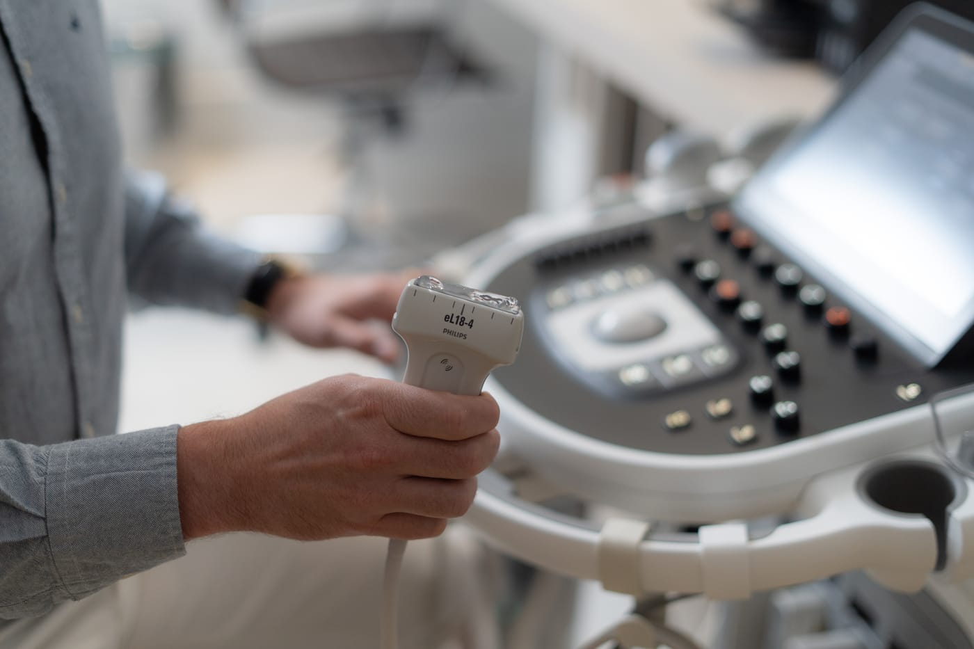 Mão do Dr. Fernando Hehn segurando o transdutor do ultrassom, usado na avaliação do joelho